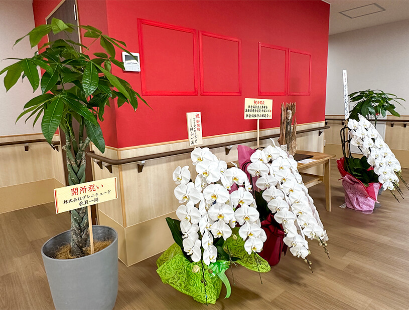 エントランスのお祝いのお花と羅漢像です